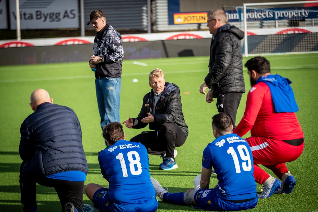 <em><em>Petter Olsen (sittende på huk) tar pausepraten mot Fredrikstads Gratelag. Roger Iversen står til høyre i bildet.</em></em>